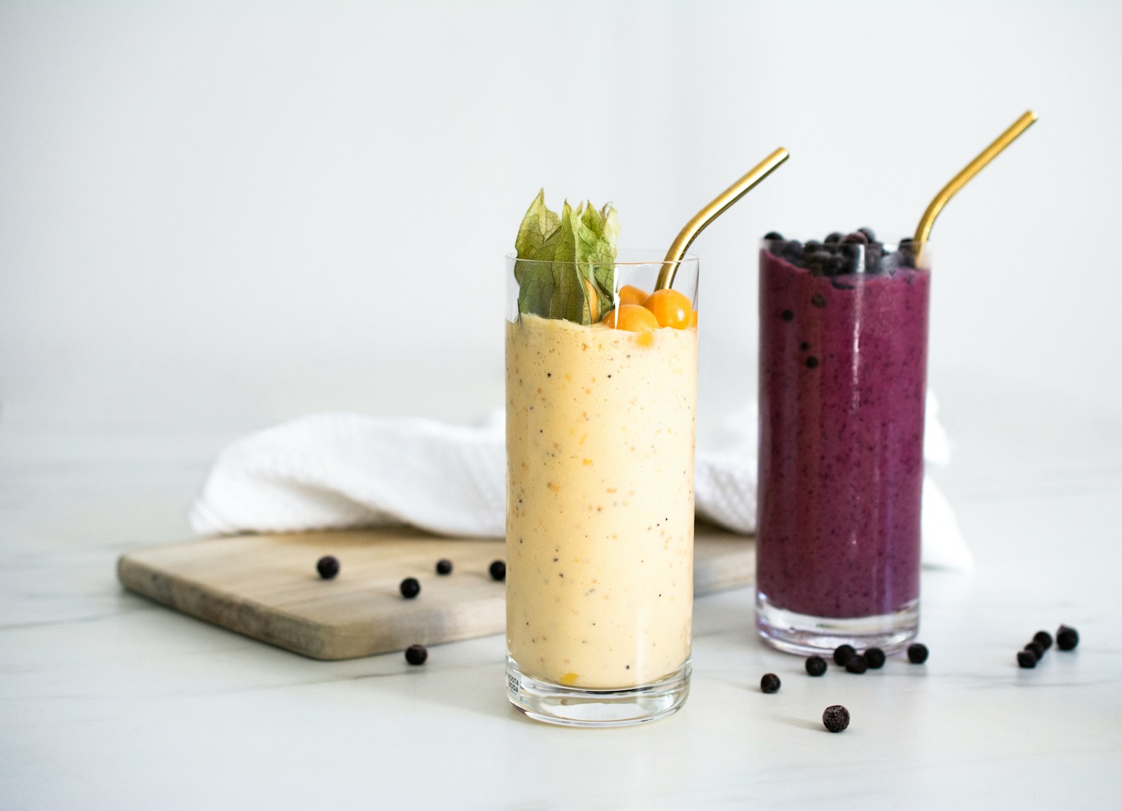 Yellow and purple blended drinks in tall glasses