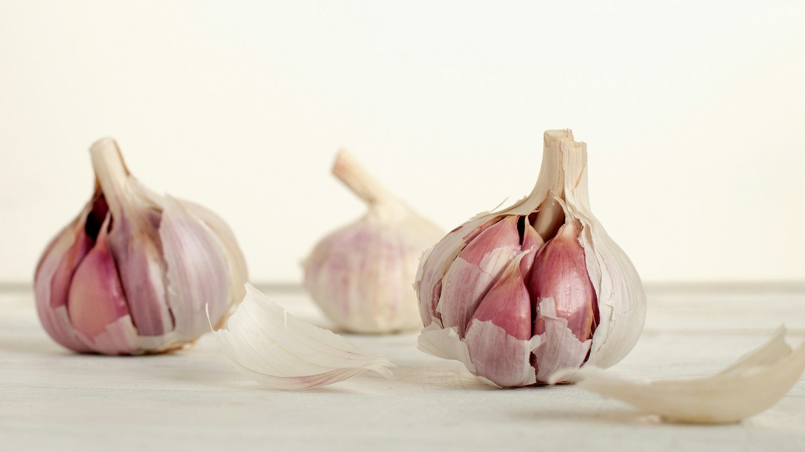 Split garlic bulbs showing cloves in purple skins