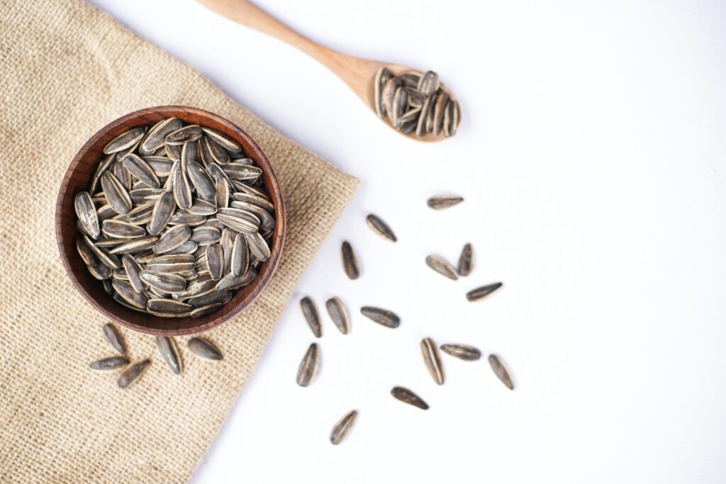 Sunflower seeds in a wooden bowl and spoon